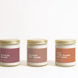 Three Holiday candles with labeled text on a white background