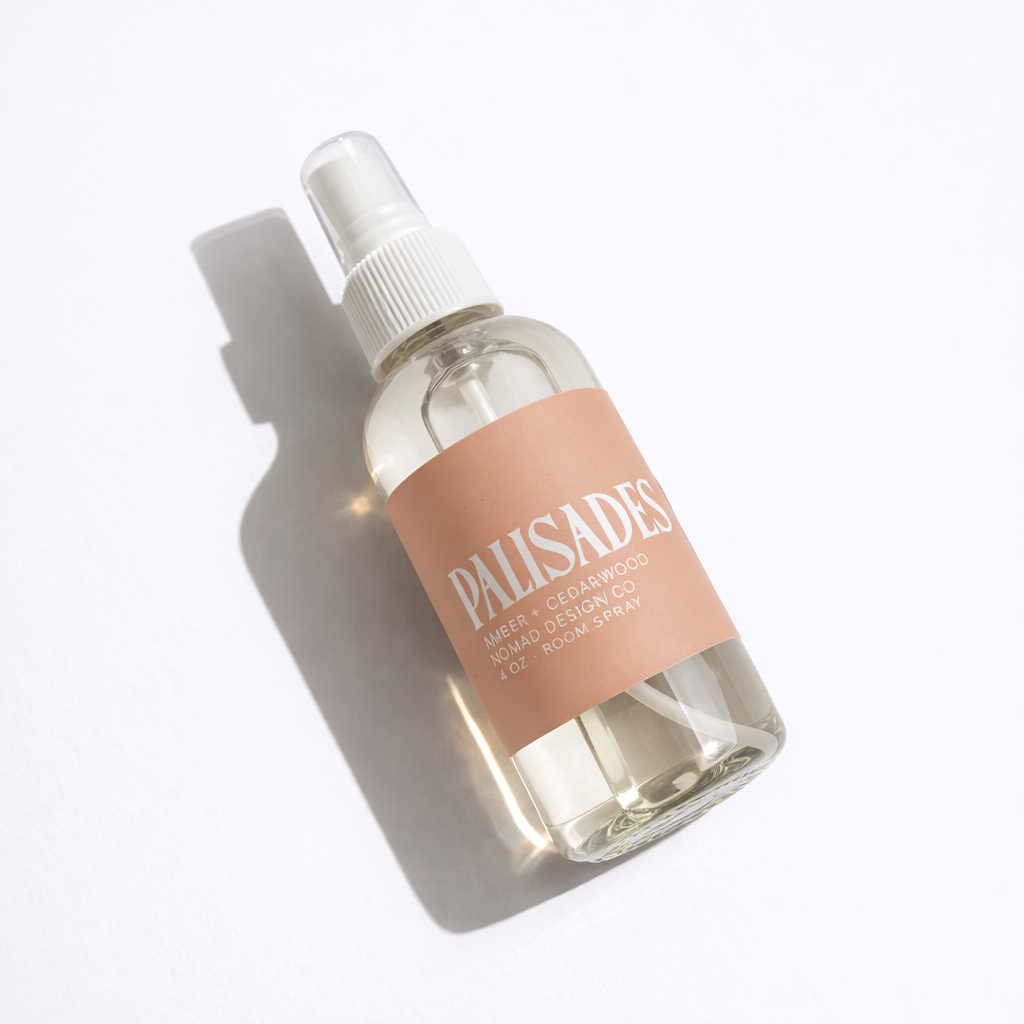 Clear spray bottle with a pink label on a white background