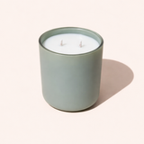 Candle in a green jar on a white background